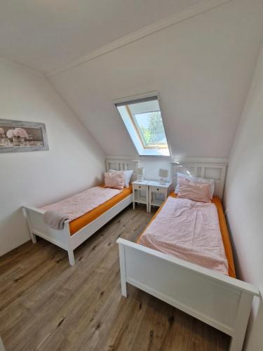 two beds in a small room with a window at Fenyves Ferienhaus 1 **** in Balatonfenyves