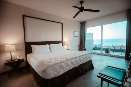 a bedroom with a large bed and a large window at Wyndham Tamarindo in Tamarindo