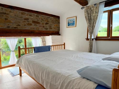 a bedroom with a bed and a large window at La Cahudiere in Saint-Martin-Landelles