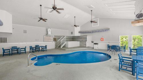 a pool in the middle of a room with blue chairs at Daylight Cove Lakefront Chic in Lake Ozark