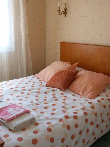 a bed with orange and white polka dot sheets and pillows at Coquette maison in Dunkerque