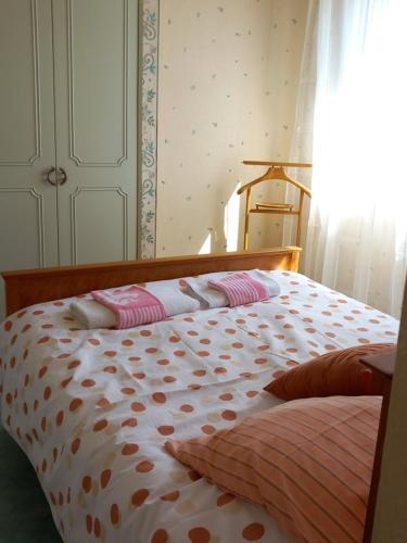 a bed with polka dot sheets and pillows on it at Coquette maison in Dunkerque