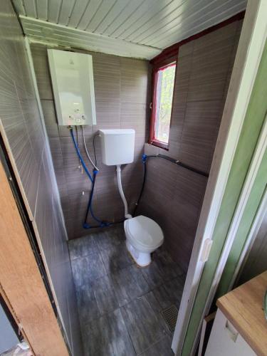 a small bathroom with a toilet and a window at CASA Petra in Bituše