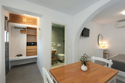 a kitchen and dining room with a table and a bedroom at Nissia Kamares in Kardamaina