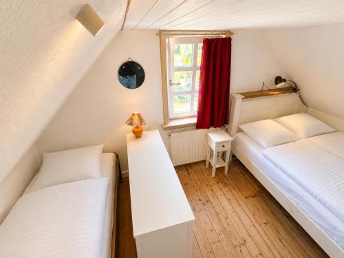two beds in a small room with a window at Beachhouse Syðrugøta in Syðrugøta