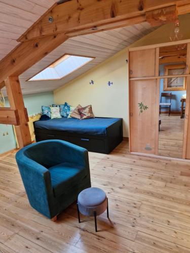 a bedroom with a bed and a chair in a room at gîte de Véreuges in Saint-Julien-des-Chazes