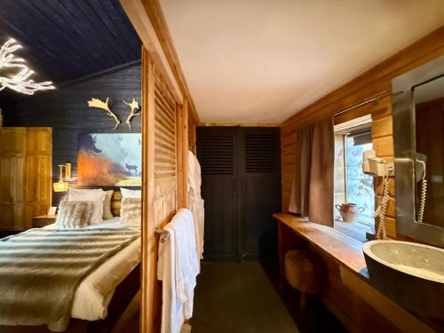 a bathroom with a bedroom with a bed and a sink at Art'Hotel & SPA Le Potin Gourmand in Cluny