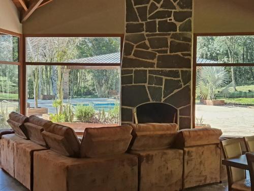 a living room with a couch and a stone wall at RadiX MISIONES in Puerto Leoni