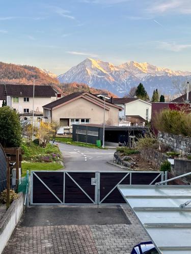 a parking lot with a gate and mountains in the background at Grosse Ferienwohnung ideal für Gruppen, nähe Thun und Interlaken in Steffisburg