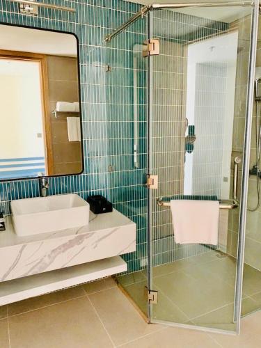 a bathroom with a shower and a sink and a mirror at Flamingos Hải Tiến LUXURY view biển tầng cao và Biệt thự 4pn in Thanh Hóa