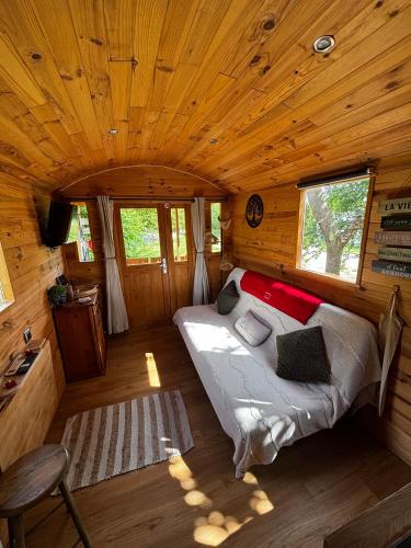 a bedroom with a bed in a wooden cabin at La Roulotte du Maine SAINTES in Saintes
