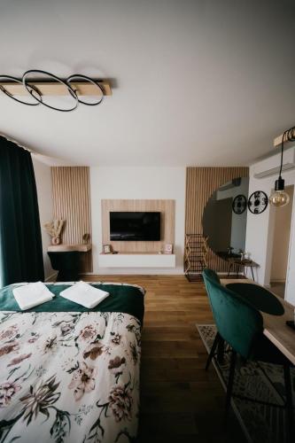 a bedroom with a bed and a table and a desk at D Mol Studio apartman in Tuzla