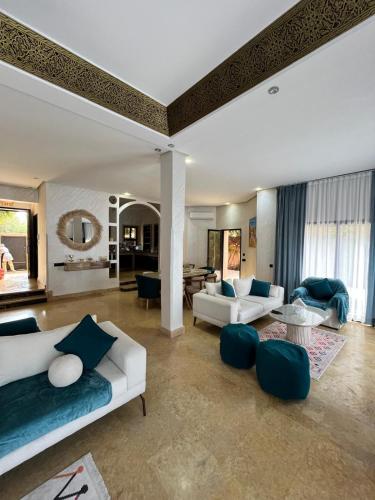 a living room with two white couches and a table at Villa de prestige à Marrakech in Marrakesh