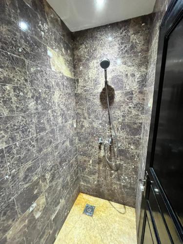 a bathroom with a shower with a stone wall at Villa de prestige à Marrakech in Marrakesh