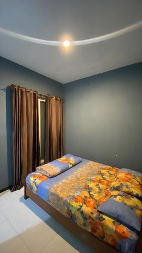 a bedroom with a bed with a colorful comforter at Aby's Guest House in Tlekung
