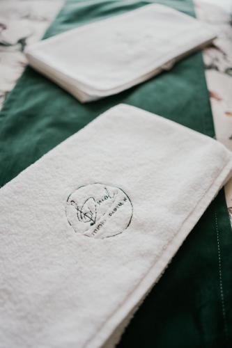 a white napkin with a circle on it on a bed at D Mol Studio apartman in Tuzla