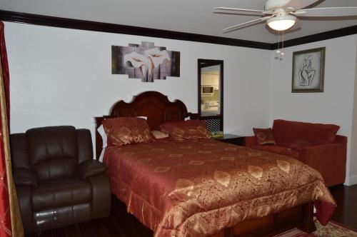 a bedroom with a bed and a leather chair at Lakeview Studio Apartments On Golf Course in Freeport