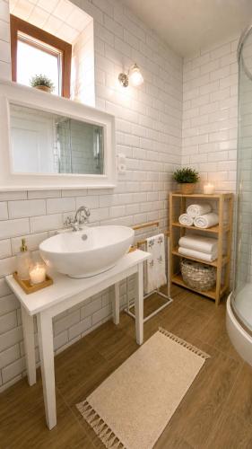 a white bathroom with a sink and a tub at Rusínska chyža in Ulič