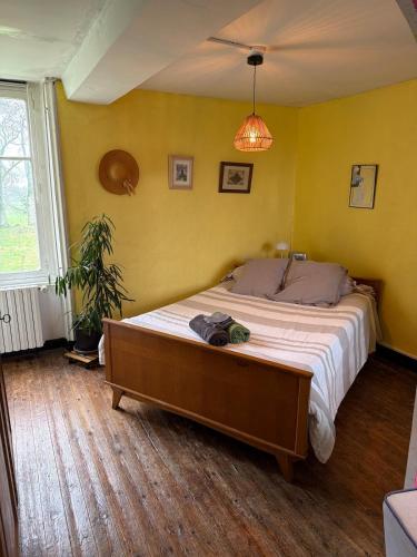 a bedroom with a large bed in a yellow wall at 11 Steps Rustic Charming Flat in Normandy in Aubusson