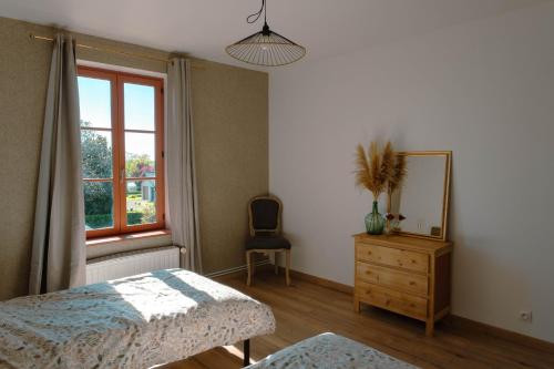 a bedroom with a bed and a dresser and a window at La batisse du Champ Manneret Maison d'hôte Falaise - logement entier in Falaise