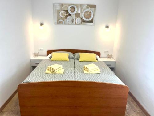 a bedroom with a bed with yellow pillows on it at Apartman Luka in Pinezici