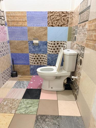 a bathroom with a toilet and colorful tiles at Green House Holiday Villa in Trincomalee