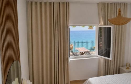 a bedroom with a window with a view of the ocean at Sea View Borsh Albania in Borsh