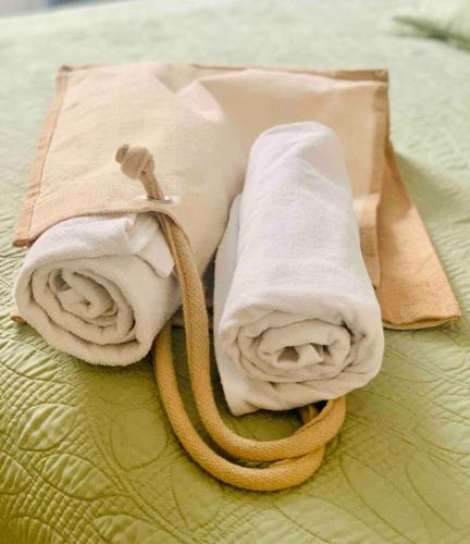 a pile of towels on top of a bed at Casita Escondida in Mérida