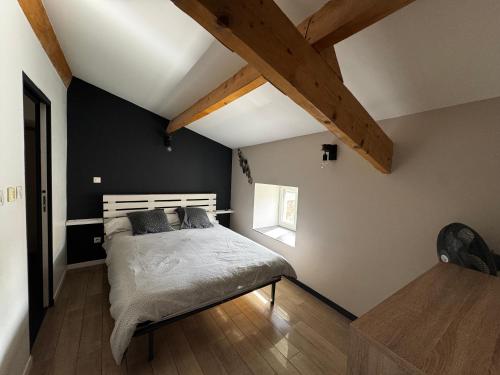 a bedroom with a bed and a wooden floor at Maison de Village 4 chambres in Sabran