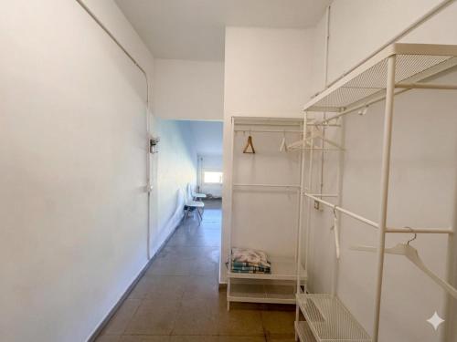 a room with white walls and a hallway with shelves at Residencia Albergue Jaca in Jaca