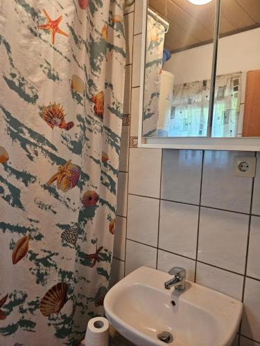 a bathroom with a sink and a shower curtain at Ana & Stela in Karlobag