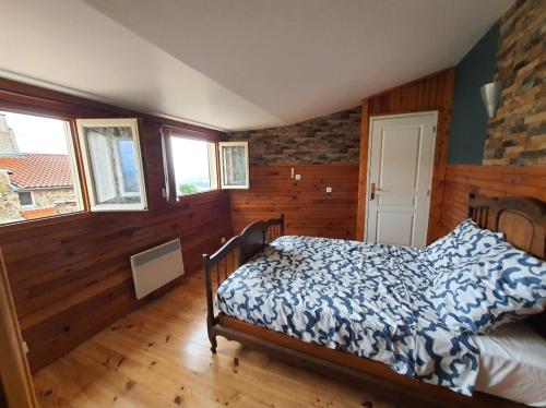 a bedroom with a bed in a room with wooden walls at Maison 2 chambres, pleine de Charme in Vic-le-Comte