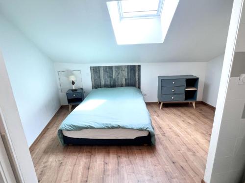a small bedroom with a bed and a skylight at Appartement 2 hyper centre d'Agen avec garage et terrasse in Agen