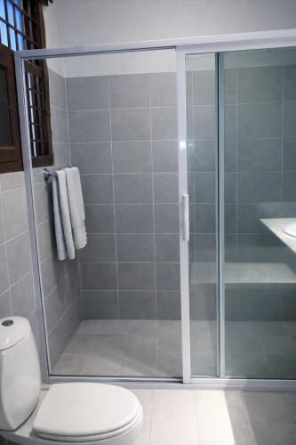 a bathroom with a glass shower with a toilet at Travellers Heaven in Karachi