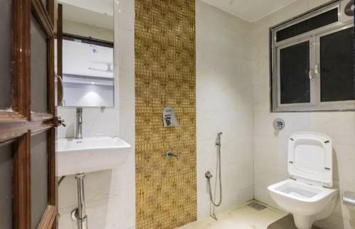 a bathroom with a toilet and a sink at Near Beach HOTEL - VERSOVA INN in Jāmb