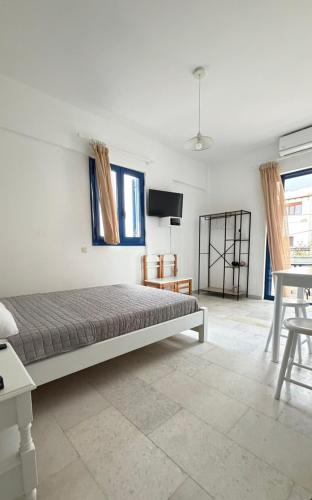 a bedroom with a bed and a tv on a wall at Ippokampos in Moutsoúna