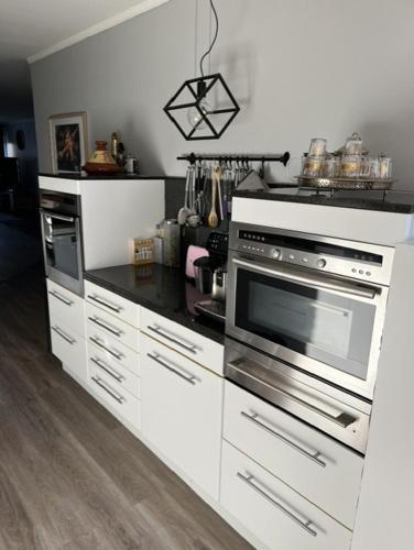 a kitchen with stainless steel appliances and white cabinets at Groene tent voor 2 personen, 1 km van tomorrowland in Boom