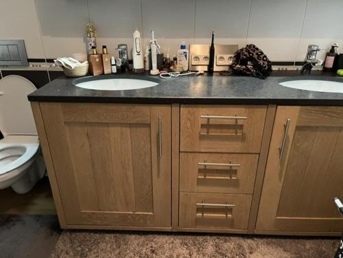 a bathroom with two sinks and a toilet at Groene tent voor 2 personen, 1 km van tomorrowland in Boom