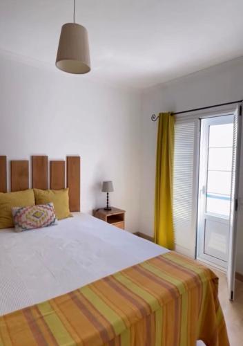 a bedroom with a large bed and a window at Praia Verde Residence in Praia Verde