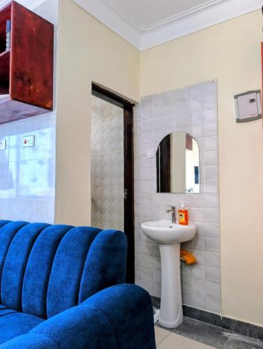 a bathroom with a blue couch and a sink at Dorado Homestay, Chaani in Mombasa
