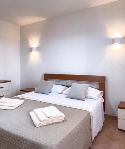 a bedroom with a large bed with towels on it at La Ginestra - Casa Vacanze in Porto Alabe
