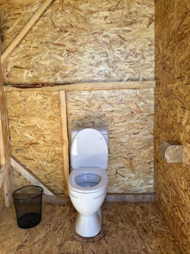 a bathroom with a white toilet in a stone wall at Azamat Nomad Camp in Song-Kul