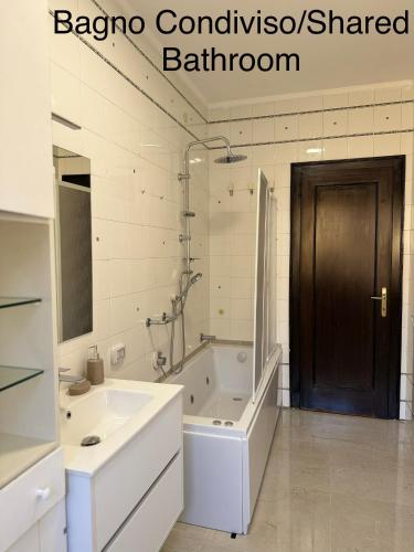 a bathroom with a white tub and a sink and a door at First Dream Mestre in Mestre