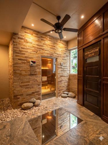 a lobby with a stone wall and a door at Chaba CBP Chiang Mai in Chiang Mai