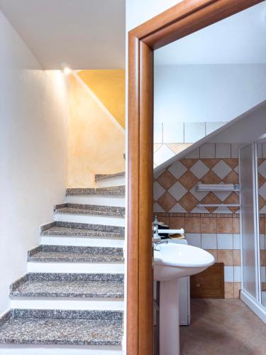 a bathroom with a sink and a staircase at La Ginestra - Casa Vacanze in Porto Alabe