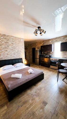 a bedroom with a large bed and a brick wall at Panorama Gora in Kutaisi