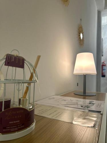 a desk with a lamp and a glass container on it at Central City Apartment of Asti in Asti