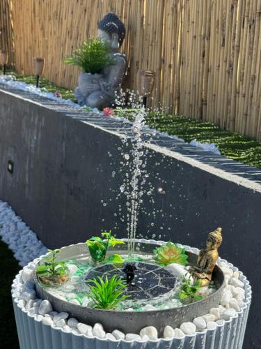 a bird bath with a fountain in a garden at Satori House in Sanremo
