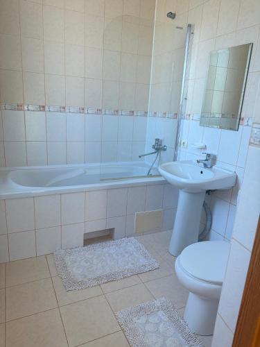 a bathroom with a tub and a toilet and a sink at Садиба Villa Bella in Velyatyn