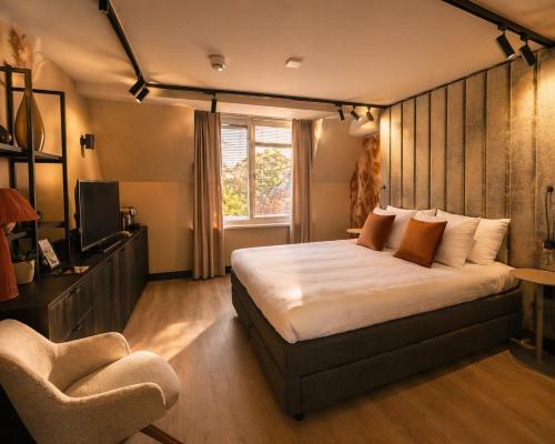 a bedroom with a bed and a chair at Boutique Hotel, Restaurant & Wellness Westerburcht in Westerbork